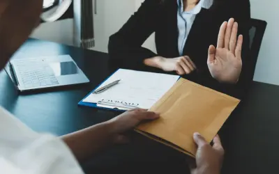 Une main tend une enveloppe, l'autre la refuse. Une scène évoquant le délai réponse inspection du travail licenciement salarié protégé.