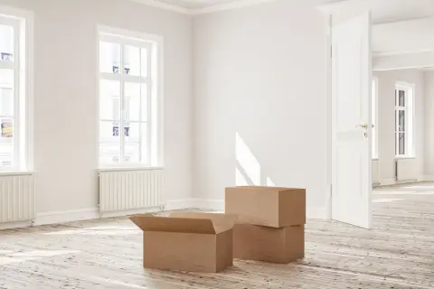 Appartement vide avec cartons, prêt à emménager. La lumière du soleil traverse les fenêtres, évoquant un nouveau départ, peut-être grâce à la loi Borloo.