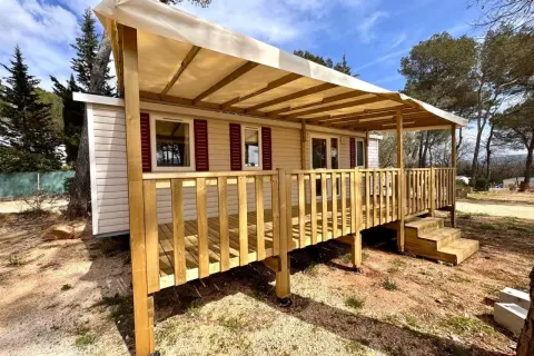 Mobil-home avec terrasse en bois sous un auvent, dans un cadre verdoyant. Une image qui pourrait illustrer la jurisprudence mobil-home.