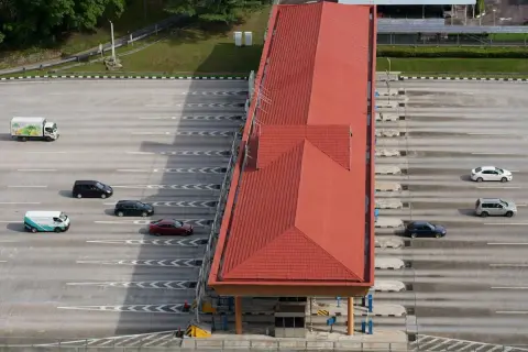 Vue aérienne d'une station de péage avec plusieurs voitures et un camion. Attention à ne pas recevoir d'amende péage en payant votre passage.