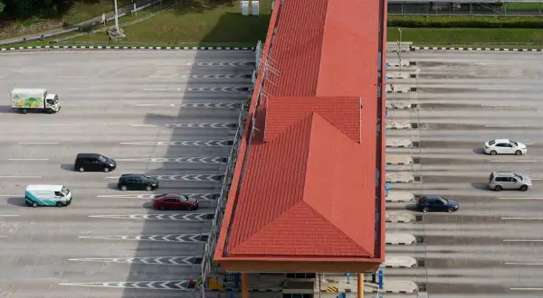 Vue aérienne d'une station de péage avec plusieurs voitures et un camion. Attention à ne pas recevoir d'amende péage en payant votre passage.